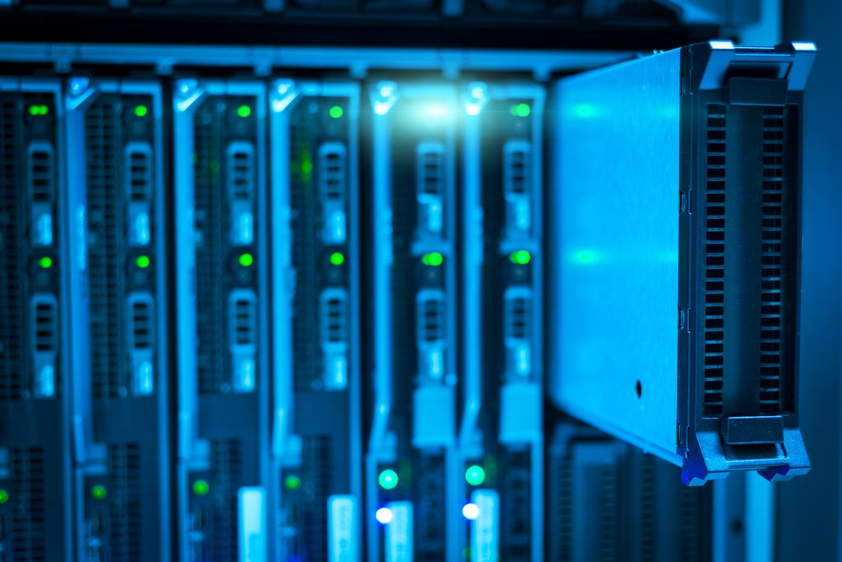 Rows of illuminated server racks in a data centre, lit blue, representing cloud infrastructure.